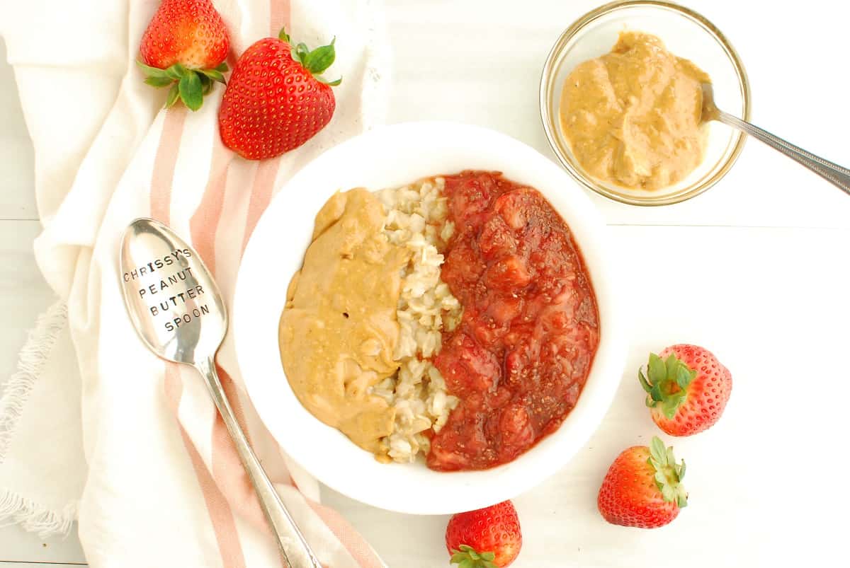 A bowl of oatmeal topped with peanut butter and chia jam.