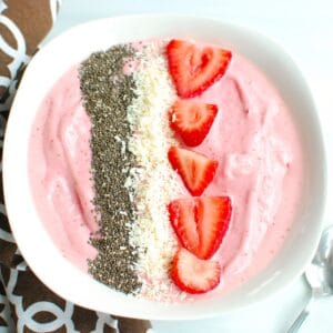 Strawberry banana smoothie bowl with toppings.