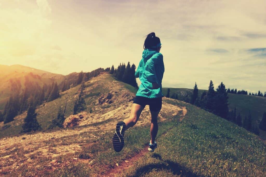 A woman running outdoors on a trail.