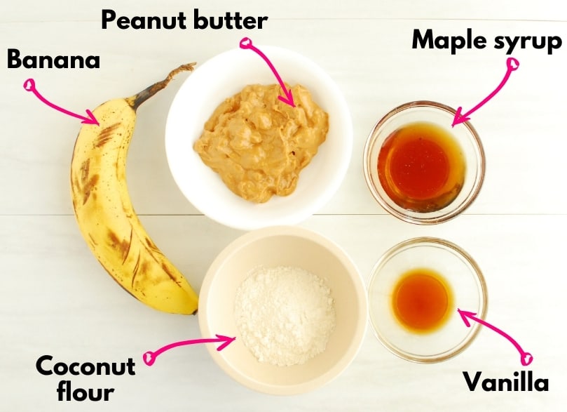 The ingredients for a recipe - a banana, peanut butter, vanilla, maple syrup, and coconut flour.