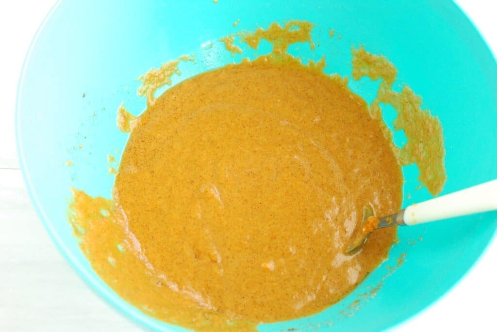 Pumpkin puree, yogurt, oil, brown sugar, egg, pumpkin pie spice, and vanilla mixed together in a bowl.