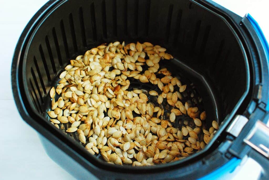 Air fryer pumpkin seeds in the basket.