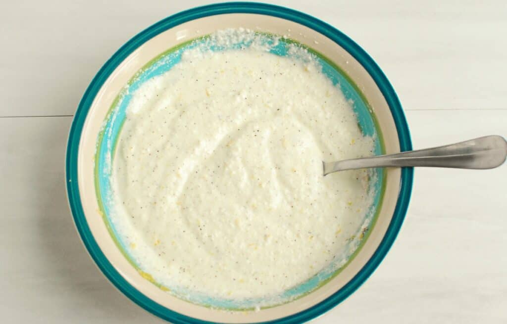 A bowl of ricotta mixed with lemon juice, lemon zest, salt, pepper, and olive oil.