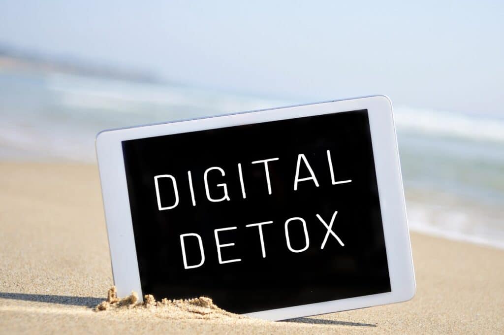 A tablet on the beach that says "Digital Detox".