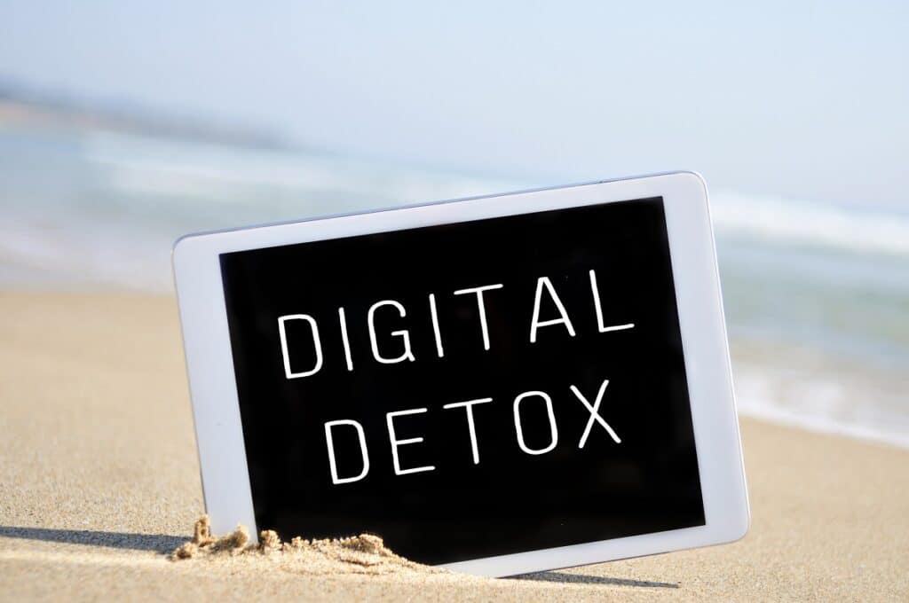 A tablet on the beach that says "Digital Detox".