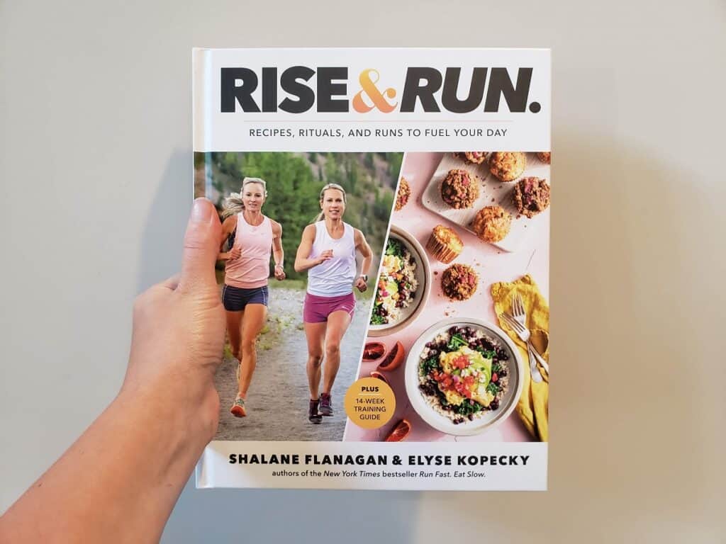 A woman's hand holding the Rise and Run book.