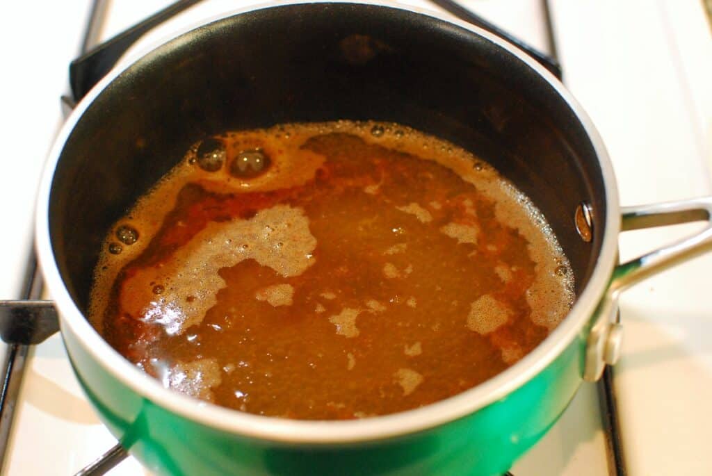 Water, cinnamon, honey, and lemon juice in a pot.