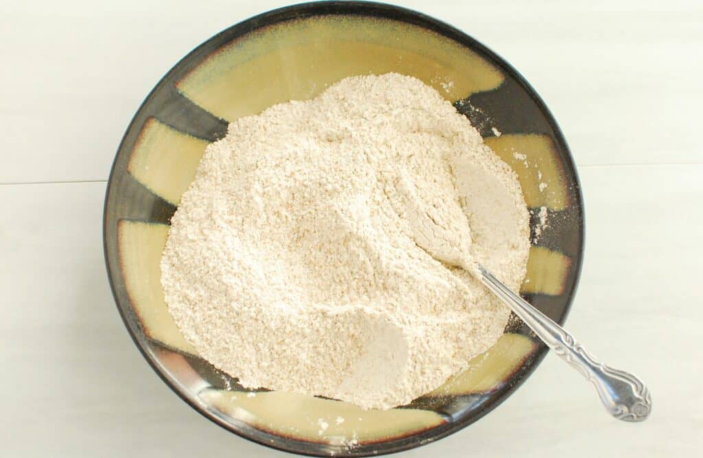 Flour, baking soda, and salt mixed together in a bowl.