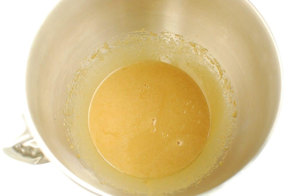 A bowl with olive oil, sugar, brown sugar, egg, and vanilla mixed together.