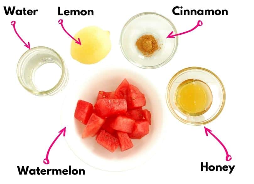 A bowl of watermelon, a lemon, water, cinnamon, and honey, all on a white background.