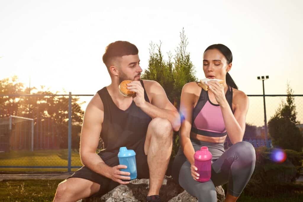 Two runners eating a meal outside.