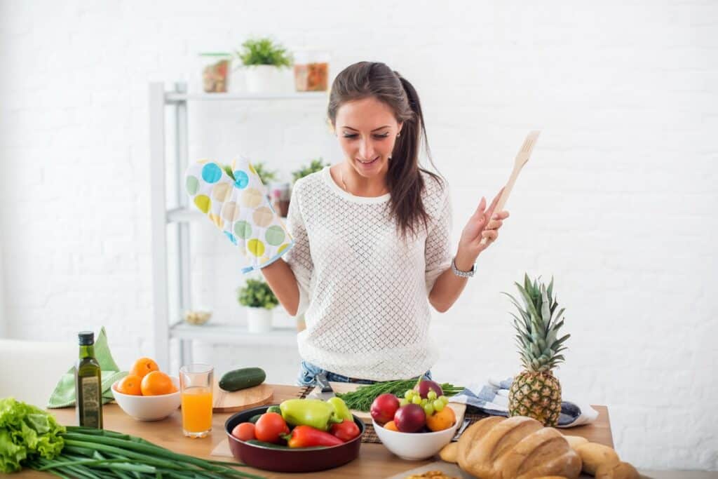 A woman preparing dinner in the kitchen the night before a road race.