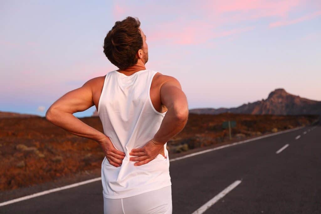 A runner outside holding his back.