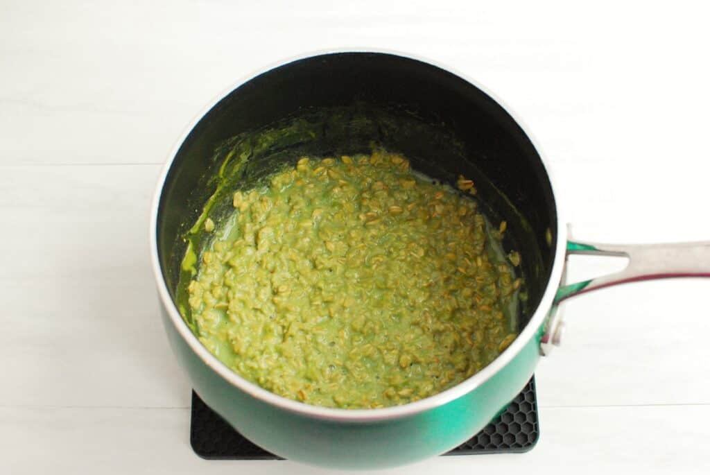 Cooked matcha oatmeal in a small pot.