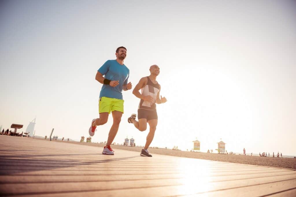 Two male friends doing an easy-paced base building run outside.