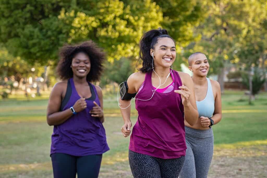 A group of female joggers working on base building by doing easy runs at a park.