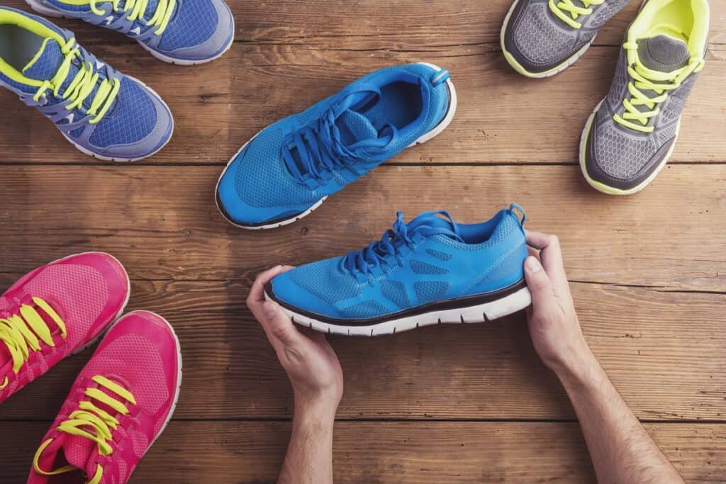 Several pairs of shoes on a wooden backdrop.