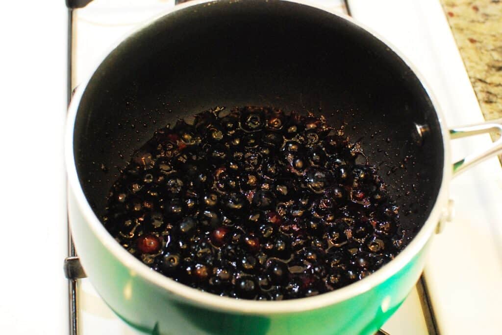 Blueberries and maple syrup in a pot after being cooked for five minutes.