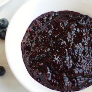 A white bowl full of blueberry chia jam.