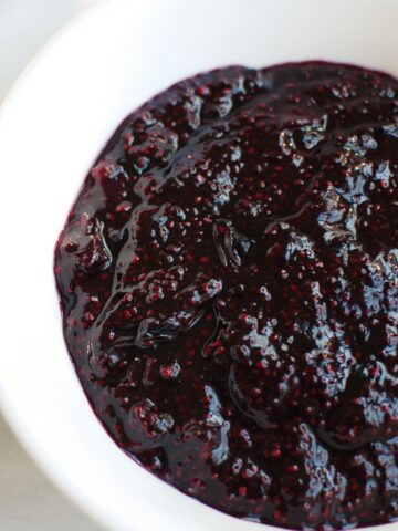 A white bowl full of blueberry chia jam.