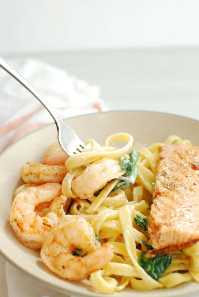 A fork twirling in a bowl of pasta.