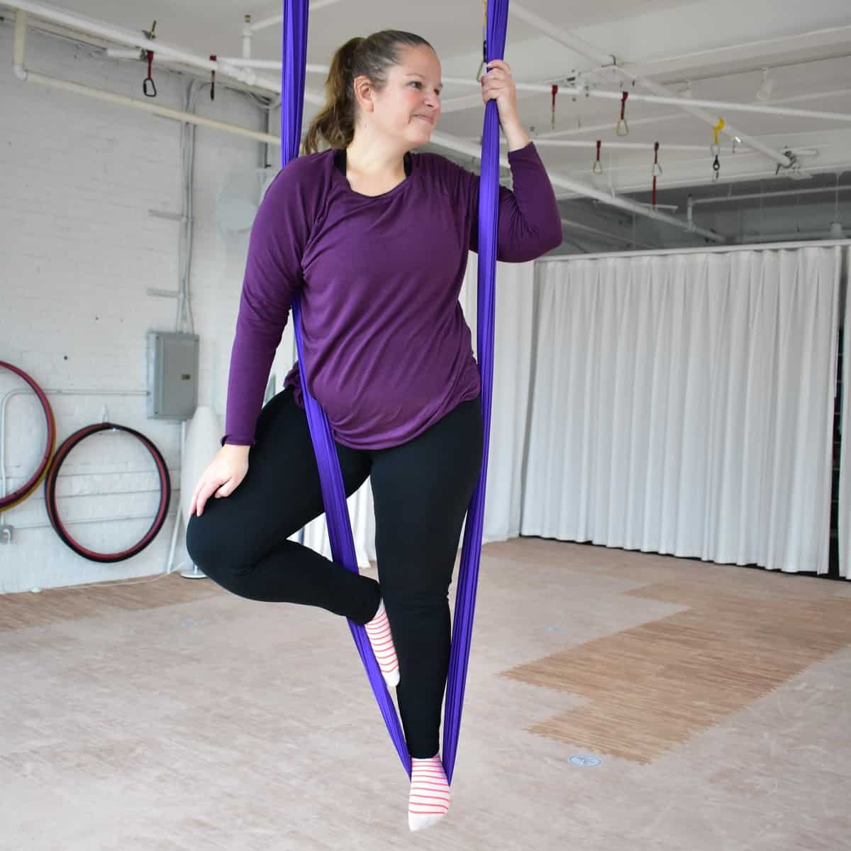 A woman doing aerial yoga.