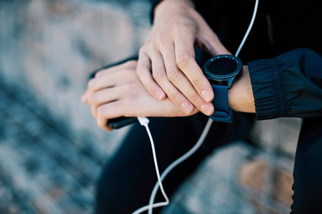 A woman looking at her smartwatch after a run.