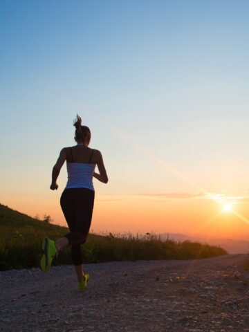 A woman running outside around sunset.