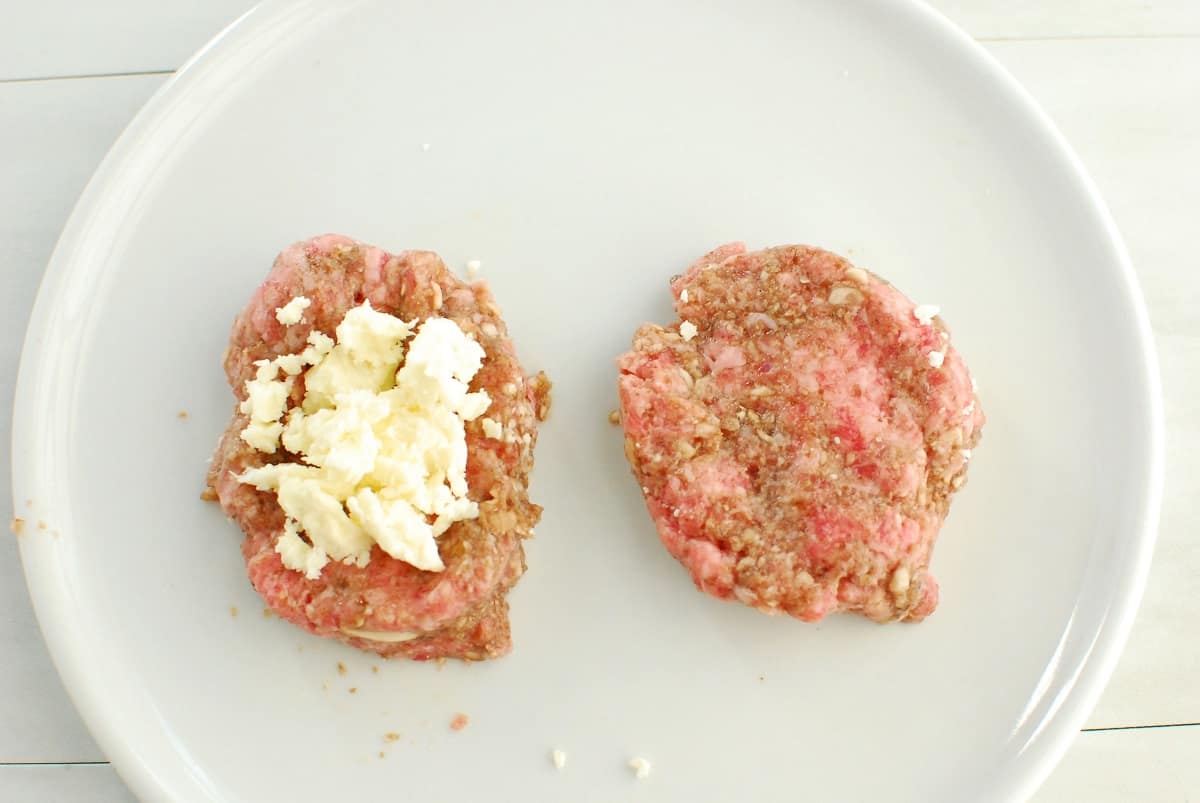 A lamb patty with feta placed on top.