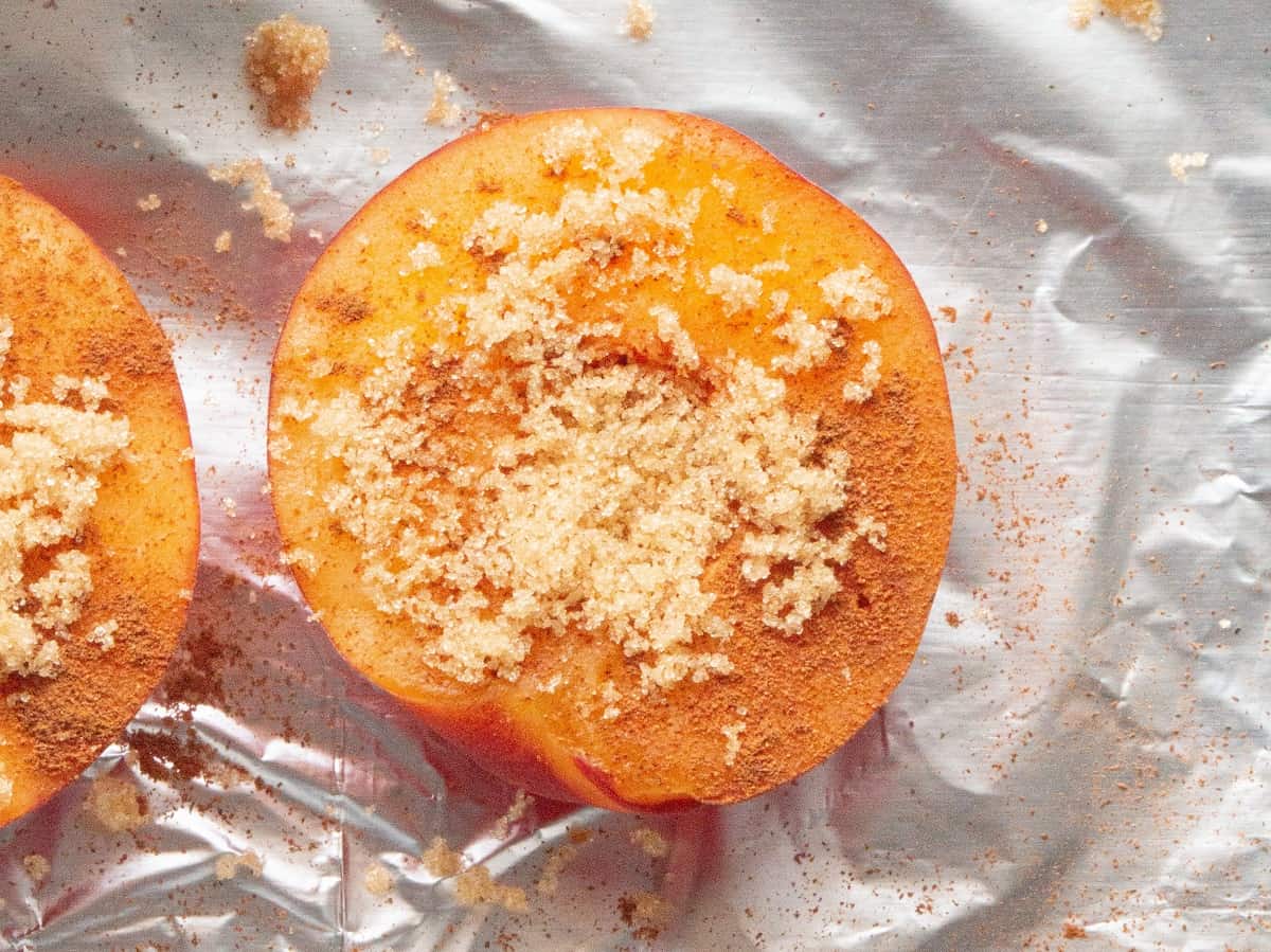A peach half topped with brown sugar and cinnamon.