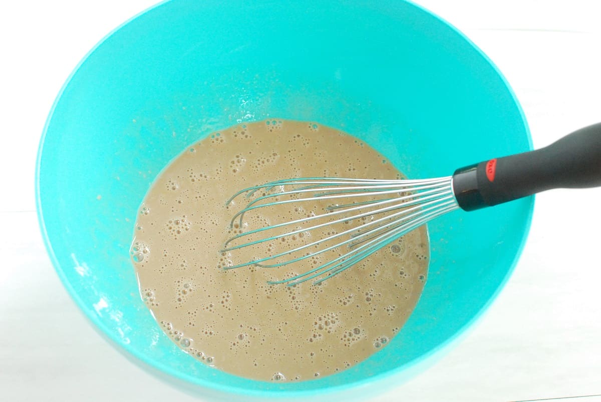 Eggs, oil, vanilla, and the chocolate milk mixture whisked together in a bowl.