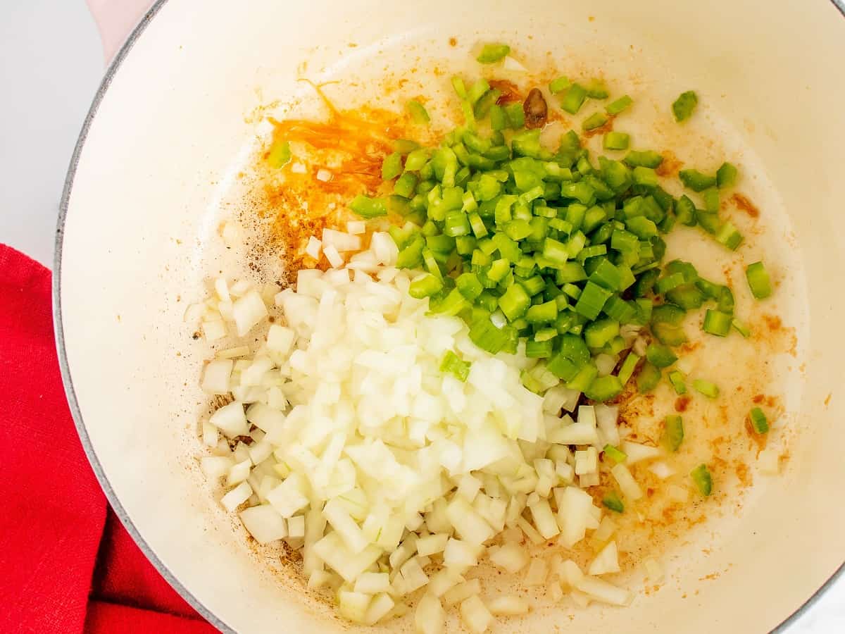 Onion and celery cooking in a pot.