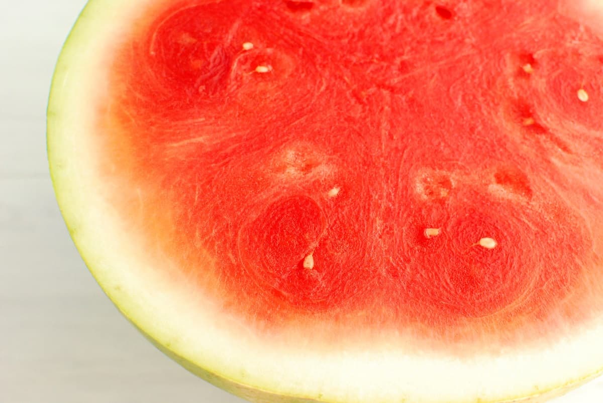 Half of a watermelon, showing the flesh and rind.