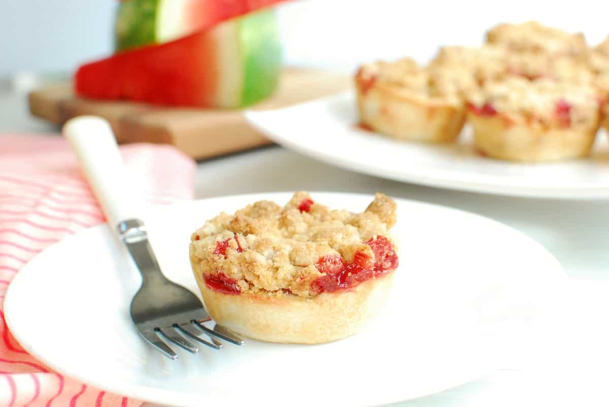 One mini watermelon pie on a plate with a fork.