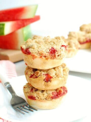 A stack of several strawberry watermelon rind mini pies on a plate.