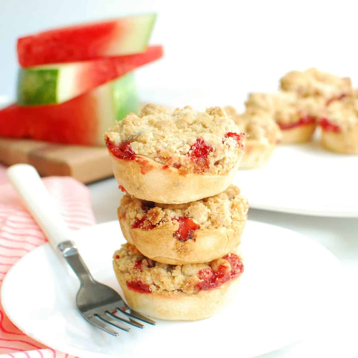 A stack of several strawberry watermelon rind mini pies on a plate.