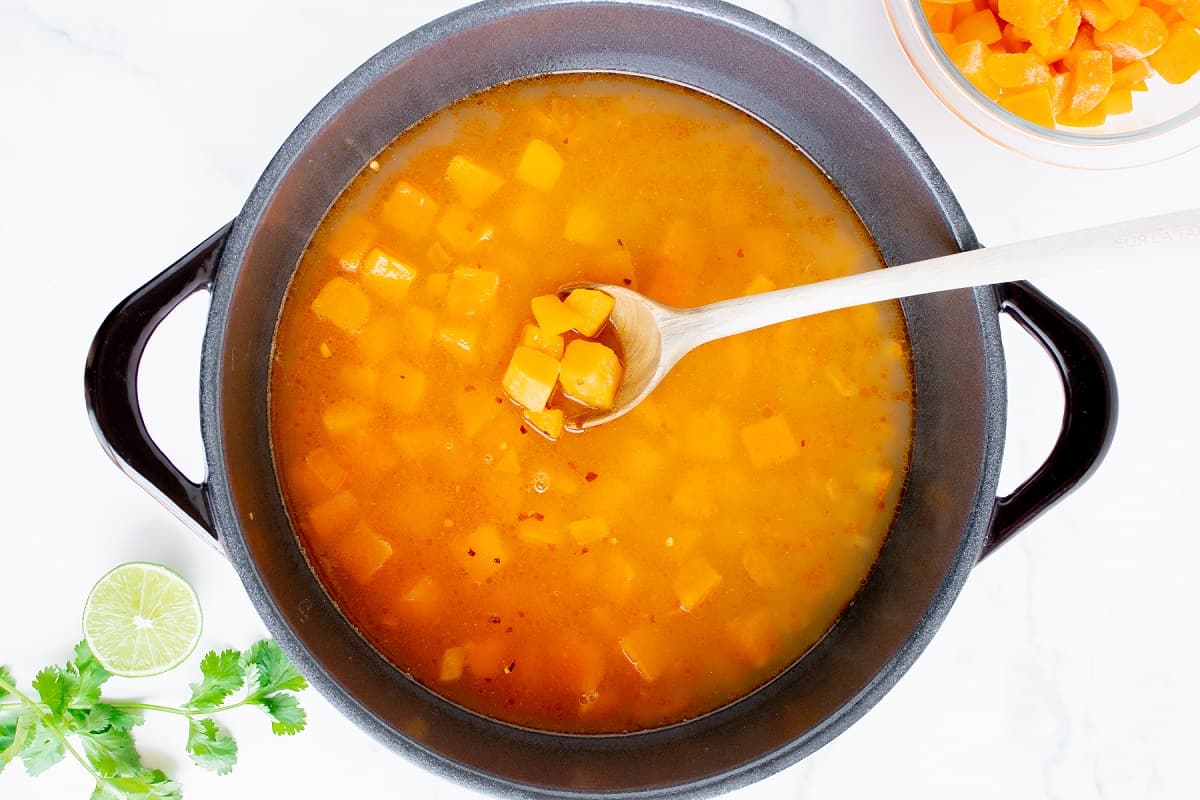 Butternut squash and broth added to the pot.