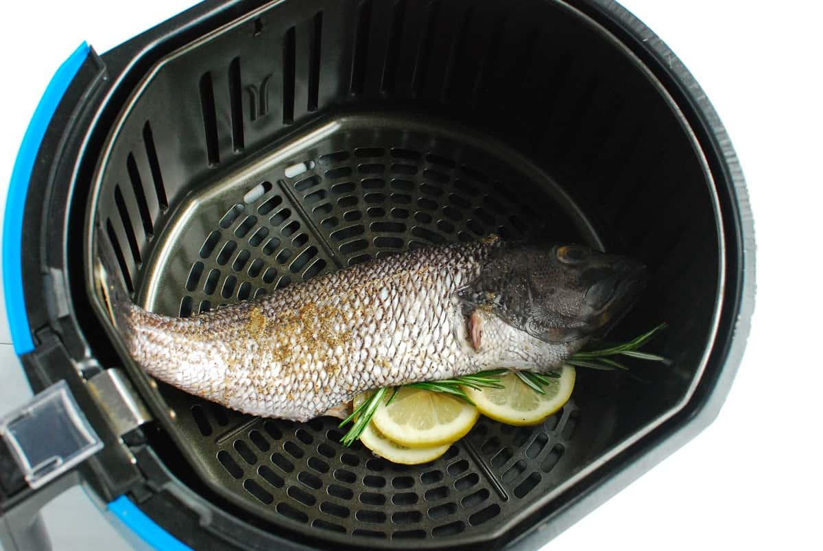 Uncooked black sea bass in the air fryer basket.