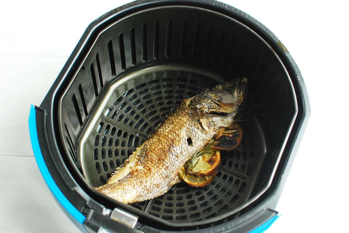 A whole fish after being cooked in the air fryer basket.