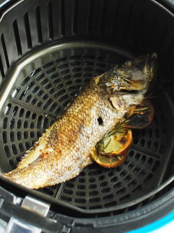 A whole fish cooked in the air fryer basket.