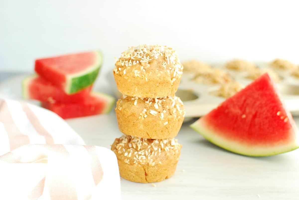 Three coconut watermelon muffins stacked on top of each other.