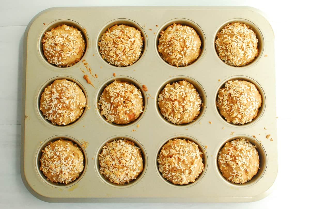 Freshly baked coconut watermelon muffins in a muffin tin.
