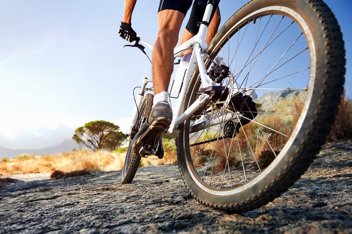 A man riding a mountain bike on uneven ground.