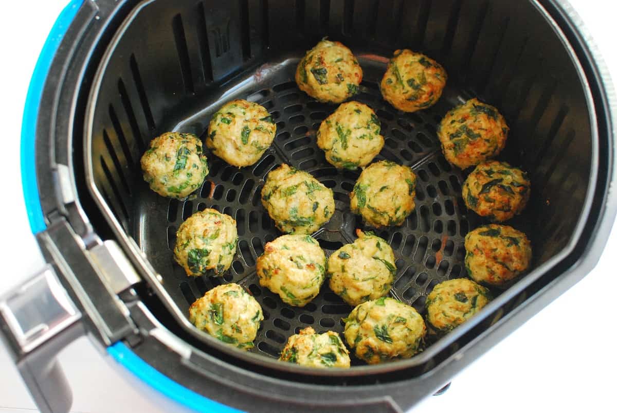 Meatballs in the air fryer basket after cooking.