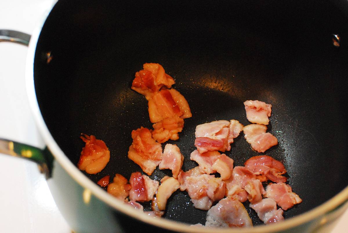 Bacon cooking in a pot.