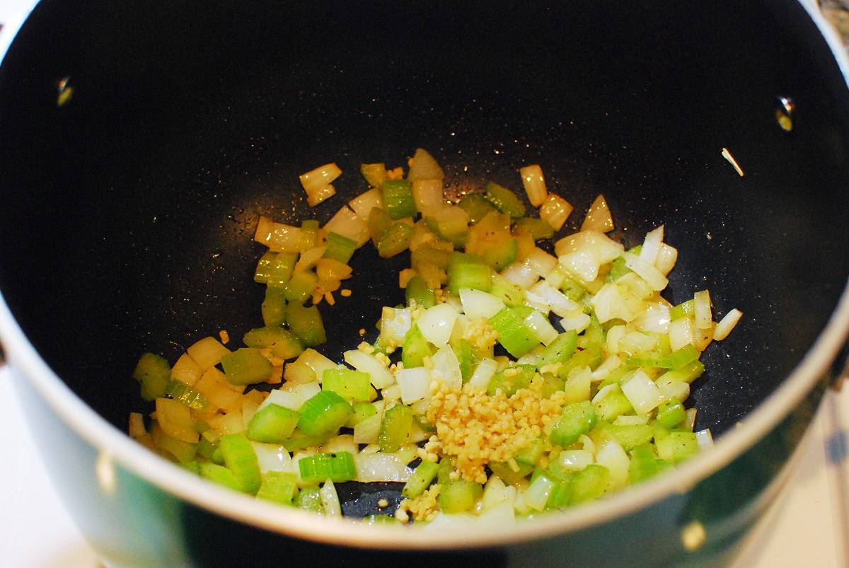 Celery, onion, and garlic cooking in a pot.
