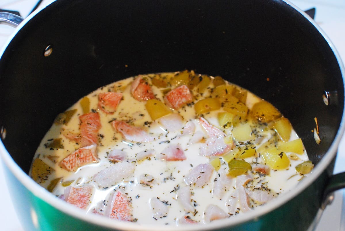Fish chowder simmering in a pot.