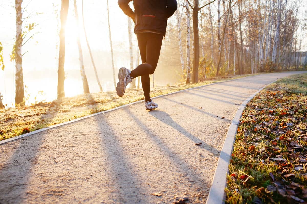 A man running on a path at sunrise.