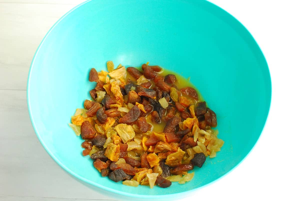 Dried fruit soaking in a orange juice in a bowl.