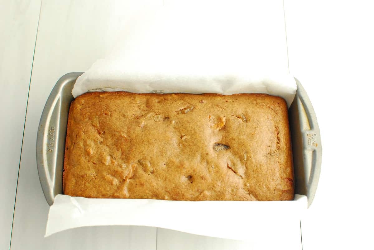 A baked loaf of fruitcake in a loaf pan.